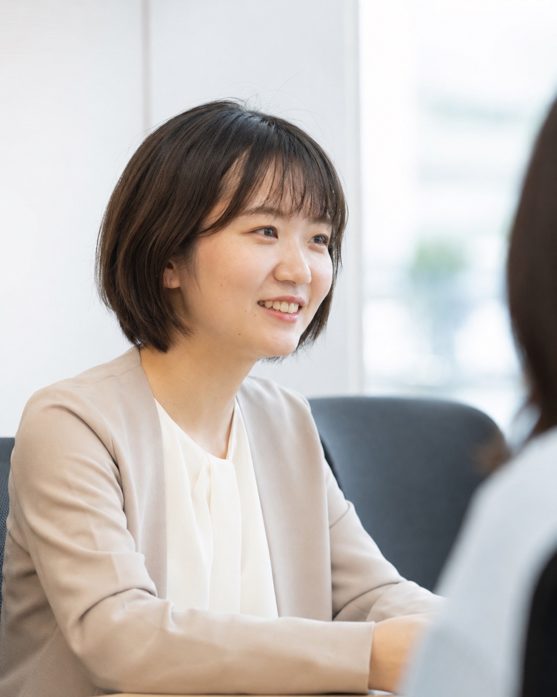 対話をしながら笑顔を見せる社員